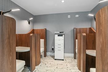 A bathroom with four stalls and a toilet and a sink